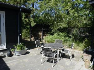 une table et des chaises assises sur une terrasse dans l'établissement Holiday Home Rami - from the sea in Sealand by Interhome, à Nykøbing Sjælland