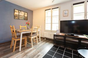 un salon avec une table à manger et une télévision dans l'établissement FullHouse - Halle - R6 Apartments - SmartTV - Nespresso, à Halle-sur-Saale 14 autres photos