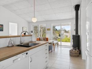 - une cuisine avec des placards blancs et un évier dans l'établissement Holiday Home Nille - 485m to the inlet in Sealand by Interhome, à Ølsted