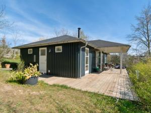 een groen tiny house met een houten terras bij Holiday Home Nille - 485m to the inlet in Sealand by Interhome in Ølsted