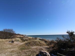 a sandy beach with the ocean in the background at Holiday Home Nada - 200m from the sea in Bornholm by Interhome in Vester Sømarken
