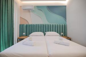 1 dormitorio con 2 camas blancas y cortinas verdes en La Maison Boutique Hotel, en Ksamil