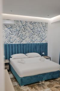 Un dormitorio con una cama con una pared azul y blanca en La Maison Boutique Hotel, en Ksamil