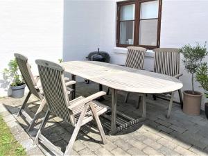 una mesa de madera y sillas en un patio en Apartment Bena - 150m from the sea in Sealand by Interhome, en Dronningmølle