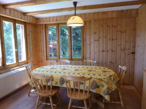 jadalnia ze stołem i oknami w obiekcie Holiday Home Moncalme by Interhome w mieście Crans-Montana