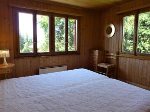 sypialnia z dużym białym łóżkiem i oknami w obiekcie Holiday Home Moncalme by Interhome w mieście Crans-Montana