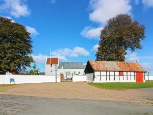 een wit gebouw met een rood dak en een boom bij Holiday Home Gudmand - 600m from the sea in Bornholm by Interhome in Vester Sømarken