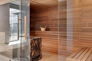 a sauna with wooden walls and a glass wall at GRANO HOTEL Solmarina in Wiślinka