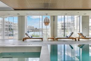 a lobby with chairs and a pool in a building at GRANO HOTEL Solmarina in Wiślinka