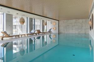 an indoor swimming pool with chairs and a swimming pool at GRANO HOTEL Solmarina in Wiślinka