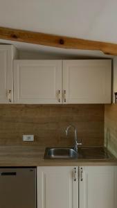 een keuken met een wastafel en witte kasten bij Le Liv On in Rijeka