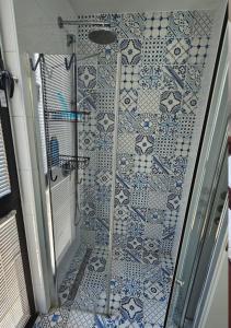 a bathroom with a shower with blue and white tiles at Tel-Aviv center, near the beach, terrace, 4 people in Tel Aviv