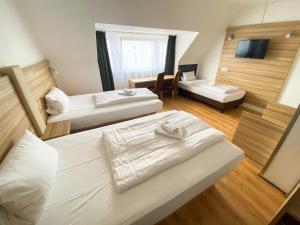 a hotel room with two beds and a couch at Limok Rooms Hamm in Hamm
