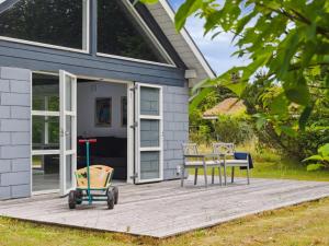 uma casa com um deque com uma mesa e cadeiras em Holiday Home Haghbarth - 400m from the sea in Lolland- Falster and Mon by Interhome em Dannemare