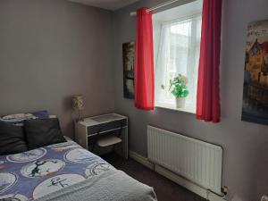 a bedroom with a bed and a window with red curtains at Tirchonaill Townhouse in Donegal