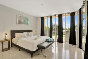 um quarto com uma cama grande e janelas grandes em Coastal Condo Deerfield Beach Retreat 3 bed 2 bath em Deerfield Beach