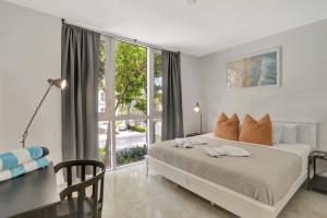 um quarto com uma cama e uma grande janela em Coastal Condo Deerfield Beach Retreat 3 bed 2 bath em Deerfield Beach
