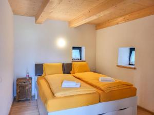 a bedroom with a bed with yellow sheets at Holiday Home Cà dal Leo by Interhome in Bignasco