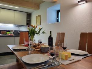a dining table with glasses of wine and cheese at Holiday Home Cà dal Leo by Interhome in Bignasco