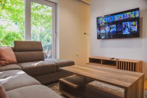 Il comprend un salon doté d'un canapé et d'une télévision à écran plat. dans l'établissement Apartment White, à Šibenik