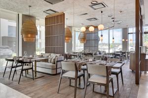 a restaurant with tables and chairs and a couch at GRANO HOTEL Solmarina in Wiślinka