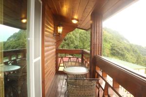 a balcony of a house with tables and chairs at Emmanuel Farm House in Ren'ai