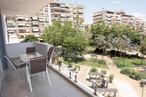 a balcony with a table and chairs on a building at Overlooking park flat close to the Piraeus Port-(DRAP-A7) in Piraeus