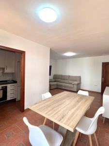 sala de estar con mesa de madera y sillas blancas en APARTAMENTO LA MURALLA, en Córdoba