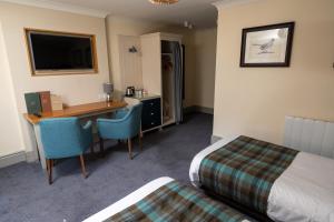 um quarto de hotel com uma secretária e uma cama em St Leonards Hotel by Greene King Inns em Saint Leonards