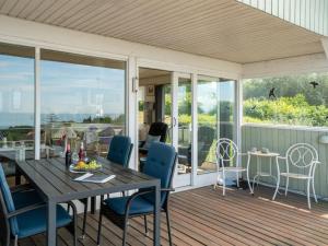 un porche cubierto con mesa y sillas en Holiday Home Eliene - 400m from the sea in Bornholm by Interhome en Hasle