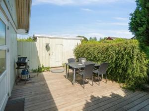 a patio with a table and chairs on a wooden deck at Holiday Home Eliene - 400m from the sea in Bornholm by Interhome in Hasle