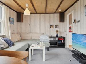 sala de estar con sofá y TV en Holiday Home Lippi - 125m from the sea in Funen by Interhome, en Mesinge