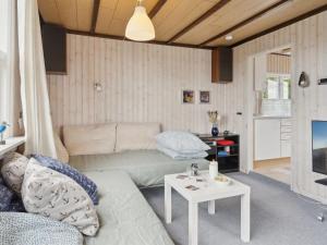 een woonkamer met een bank en een tafel bij Holiday Home Lippi - 125m from the sea in Funen by Interhome in Mesinge