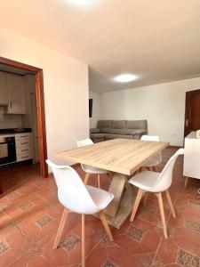 sala de estar con mesa de madera y sillas blancas en APARTAMENTO LA MURALLA, en Córdoba