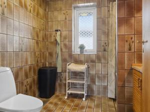 La salle de bains est pourvue de toilettes et d'une fenêtre. dans l'établissement Holiday Home Maleen - 150m to the inlet in Lolland- Falster and Mon by Interhome, à Nakskov