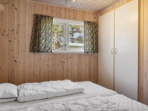 Schlafzimmer mit einem Bett und einem Fenster in der Unterkunft Holiday Home Fenja - 1-2km from the sea in Lolland- Falster and Mon by Interhome in Bøtø By