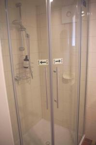 um chuveiro com uma porta de vidro na casa de banho em Darcy's Cottage on Piper em Kyneton