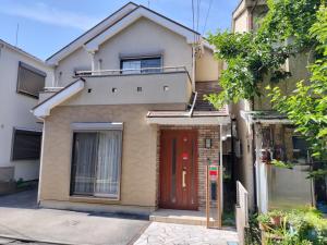 江戸川House（小岩车站400米一户建） في طوكيو: منزل فيه باب احمر على شارع