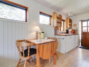 a kitchen with a wooden table and chairs at Apartment Kolja - 3km from the sea in Western Jutland by Interhome in Blåvand
