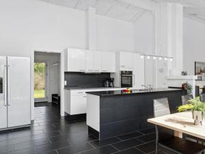 a kitchen with white cabinets and a black counter top at Holiday Home Josina - 675m from the sea in Sealand by Interhome in Tjørneholm