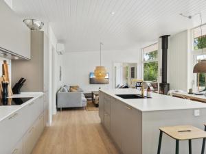cocina con armarios blancos y sala de estar. en Holiday Home Tinja - 900m from the sea in Sealand by Interhome, en Højby