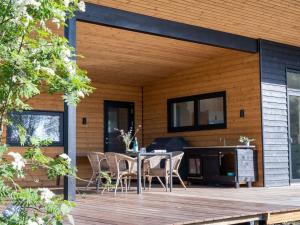 un patio con mesa y sillas en una terraza de madera en Holiday Home Toska - all inclusive - 100m to the inlet in Sealand by Interhome en Rørvig