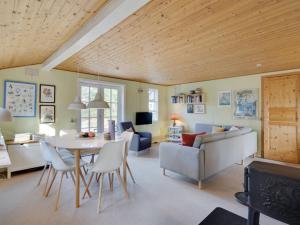 Un comedor y una sala de estar con mesa y sillas. en Holiday Home Ljuba - 700m from the sea by Interhome, en Oksbøl