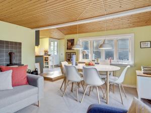 Un comedor y una sala de estar con mesa y sillas. en Holiday Home Ljuba - 700m from the sea by Interhome, en Oksbøl