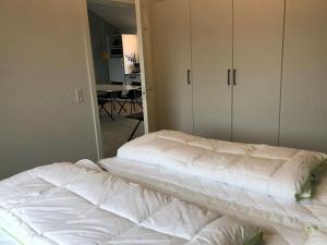 a bedroom with two white beds and a mirror at Apartment Esger - all inclusive - 900m from the sea by Interhome in Blåvand