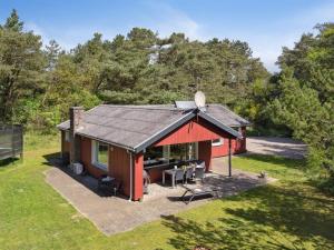 een uitzicht op een klein rood huis met een patio bij Holiday Home Keyla - 3-2km from the sea in Western Jutland by Interhome in Rømø Kirkeby