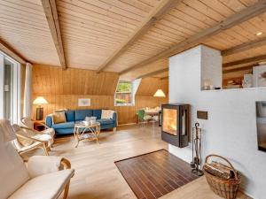 a living room with a blue couch and a fireplace at Holiday Home Sisko - 800m from the sea in Western Jutland by Interhome in Vejers Strand