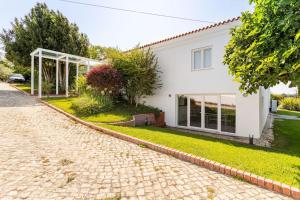 a white house with a brick driveway at Casal das Aveleiras in Cartaxo