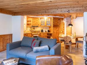 ein Wohnzimmer mit einem blauen Sofa und einer Küche in der Unterkunft Apartment Chesa Anemona al Lej by Interhome in St. Moritz