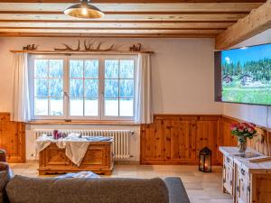 ein Wohnzimmer mit einem großen Fenster und einem TV in der Unterkunft Apartment Chesa Anemona al Lej by Interhome in St. Moritz